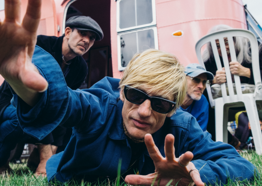 Artist kula shaker lying on grassx